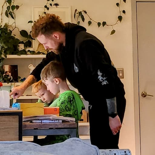 Adam pointing at some homework with my 2 kids.